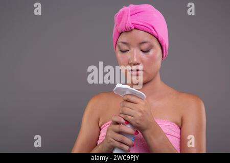 Hautpflege-Ritual einer jungen Chinesin, in Handtücher gewickelt Stockfoto