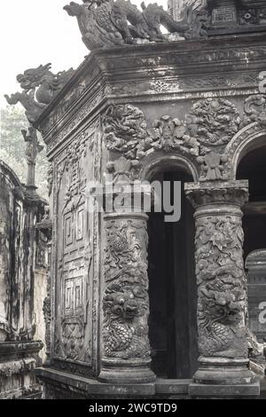 Hue City, Vietnam, 19. März 2015: Komplizierte Drachen in Wolkenschnitzereien auf einer antiken Steinsäule an der historischen Grabstätte von Khai Dinh, Vietnam Stockfoto