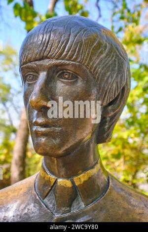 Eine lebensgroße Bronzeskulptur von George Harrison, Teil der Band The Beatles. Im touristischen Vergnügungspark Kok Tobe in Almaty, Stockfoto