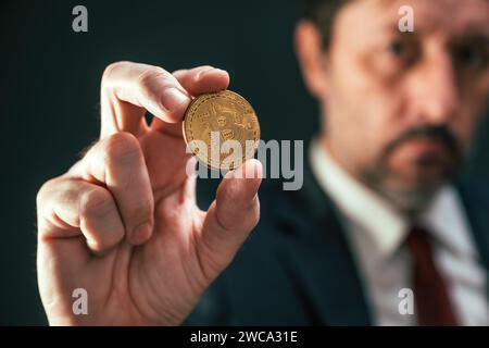 Kryptowährungshändler hält Bitcoin in der Hand Stockfoto