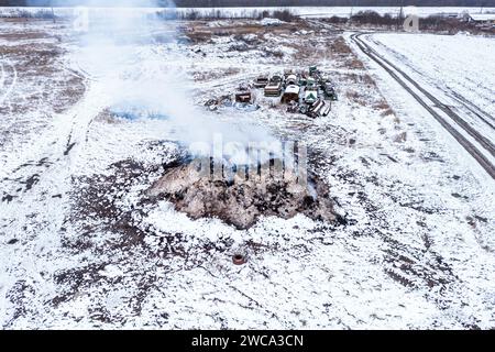 Brennender Dunghaufen auf dem Bauernhof, Luftverschmutzung und Verschmutzung, Luftaufnahme von Drohnen-pov, Hochwinkelansicht Stockfoto