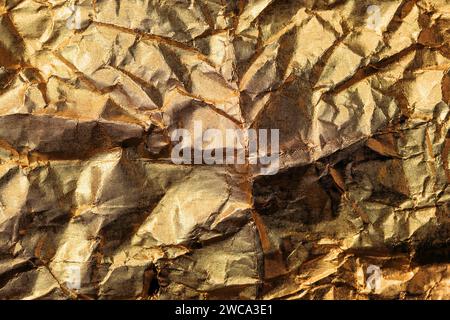 Zerknitterte goldfarbene Aluminium-Zinnfolie als Hintergrund, Draufsicht Stockfoto