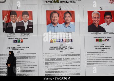 Bandung, West-Java, Indonesien. Januar 2024. Eine Frau geht an der Vision und Mission von drei indonesischen Präsidentschafts- und Vizepräsidentschaftskandidaten in Bandung vorbei, vor den Wahlen in Indonesien, die am 14. Februar 2024 stattfinden werden. (Kreditbild: © Dimas Rachmatsyah/ZUMA Press Wire) NUR REDAKTIONELLE VERWENDUNG! Nicht für kommerzielle ZWECKE! Stockfoto