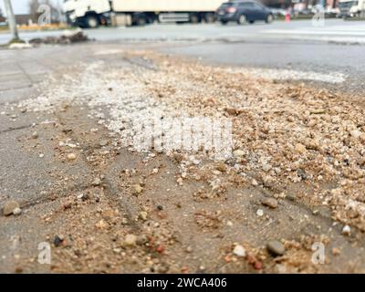 Salz auf dem Gehweg, um Schnee zu schmelzen, saubere Straßen im Winter, Autos im Hintergrund. Stockfoto