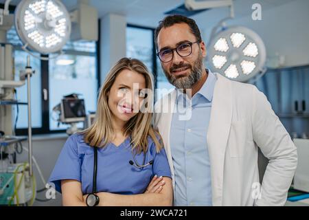 Porträt des selbstbewussten Arztes und der Krankenschwester im Untersuchungsraum. Pflegekräfte in einer modernen Privatklinik, mit Blick auf die Kamera, lächelnd. Stockfoto