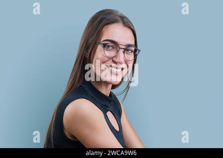 Kopfbild-Porträt einer jungen Frau in trendiger Brille auf grauem Hintergrund Stockfoto