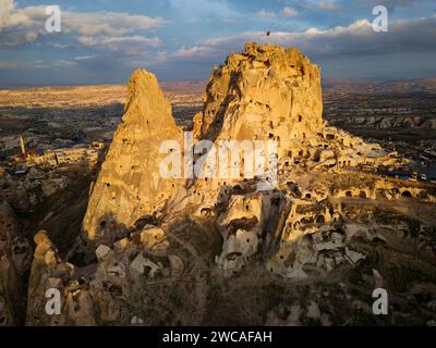Drohnenansicht des Uchisar Castle in Kappadokien, Türkei bei Sonnenuntergang. Die Leute genießen die Aussicht von der Spitze des Schlosses. Stockfoto