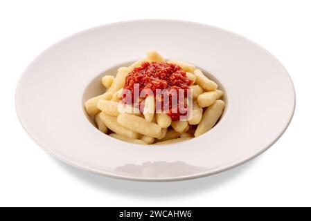 Gnocchi mit Tomatensauce in weißer Platte isoliert auf weiß mit Schnittpfad enthalten. Typische Gnocchi aus den italienischen Alpen. Gnocchi aus dem Varait Stockfoto