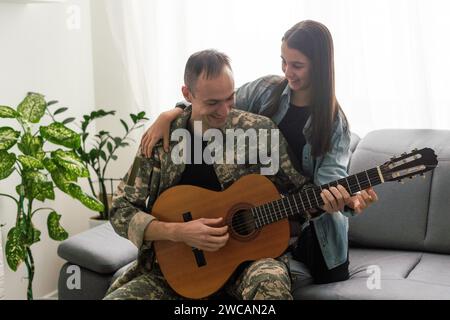 Ein Veteran und seine Tochter spielen Gitarre Stockfoto