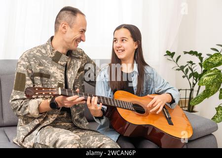 Ein Veteran und seine Tochter spielen Gitarre Stockfoto