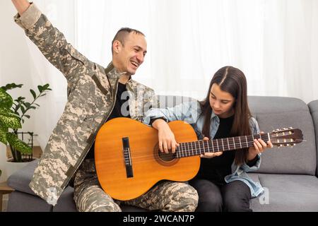 Ein Veteran und seine Tochter spielen Gitarre Stockfoto