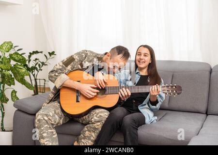 Ein Veteran und seine Tochter spielen Gitarre Stockfoto