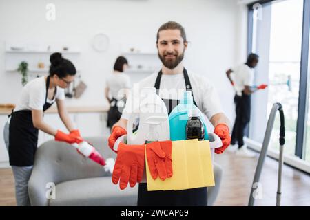 Konzentrieren Sie sich auf den Eimer mit Reinigungsmitteln in den Händen eines Kaukasiers Stockfoto