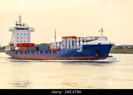 Containerschiff, das im Sommer bei Sonnenuntergang in einen Hafen fährt Stockfoto