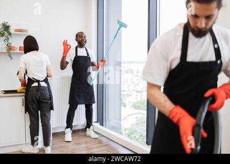 Konzentrieren Sie sich auf positive afroamerikanische Arbeiter, die Panoramafenster reinigen. Stockfoto