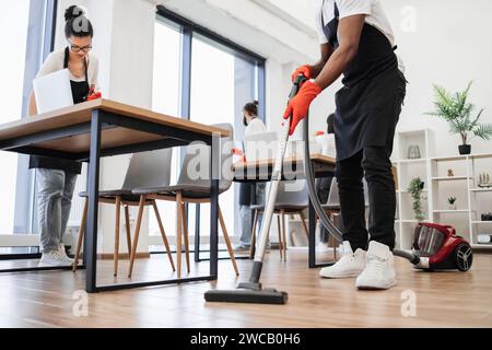 Zugeschnittene Ansicht der Hände eines afrikanischen Mannes, der Staubsauger hält. Stockfoto