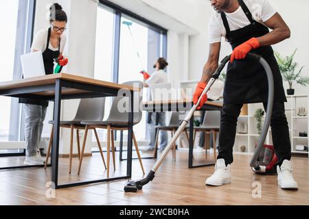 Zugeschnittene Ansicht der Hände eines afrikanischen Mannes, der Staubsauger hält. Stockfoto