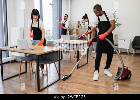 Kaukasischer Arbeiter in einer schwarzen Schürze, der Panoramafenster reinigt. Stockfoto