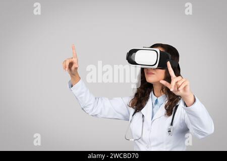 Gerät für die medizinische Ausbildung. Ärztin im Mantel mit Stethoskop mit virtueller Realität in vr-Brillen Stockfoto