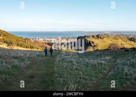 Zwei Wanderer zu Fuß im Holyrood Park, Edinburgh Schottland. Januar 2024. Stockfoto