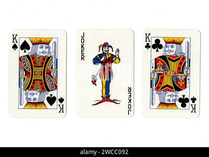 Vintage-Spielkarten, die ein Paar schwarzer Könige und einen Scherz auf weißem Hintergrund zeigen. Stockfoto