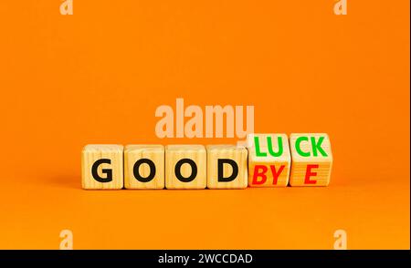 Viel Glück oder Abschiedssymbol. Concept Words Good Luck or Goodbye auf schönen Holzblöcken. Schöner oranger Tisch mit orangefarbenem Hintergrund. Business, motiva Stockfoto