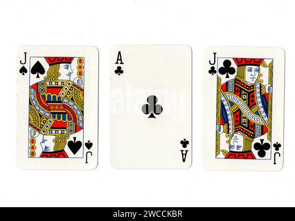 Alte Spielkarten, die ein Paar schwarze Buben und ein schwarzes Ass auf weißem Hintergrund zeigen. Stockfoto