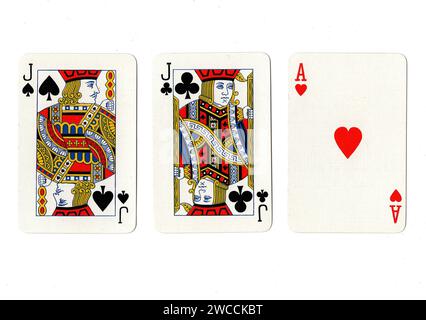 Vintage-Spielkarten, die ein Paar schwarze Buben und ein rotes Ass auf weißem Hintergrund zeigen. Stockfoto