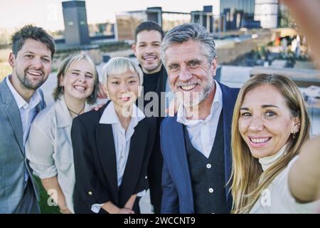 Selfie einer Gruppe glücklicher Geschäftsleute, die mit einem Telefon Fotos machen Stockfoto