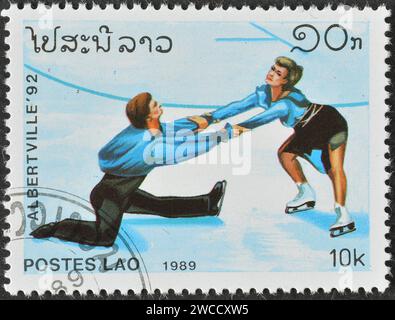 Laos - um 1989 : Briefmarke mit abgebrochenem Briefdruck von Laos, die Eiskunstlauf zeigt, Werbung für die Olympischen Winterspiele 1992 - Albertville, um 1989. Stockfoto