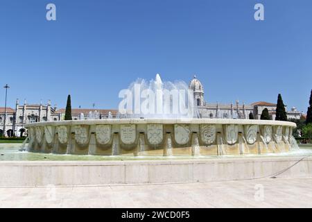 Hinter dem Brunnen im Jardim da Praca do Império, einem Garten in Lissabon. Das Kloster Jerónimos oder Hieronymitenkloster ist ein ehemaliges Kloster des Ordens des Heiligen Jerome in der Nähe des Flusses Tejo in der Pfarrei Belém in der portugiesischen Gemeinde Lissabon. Sie wurde im 16. Jahrhundert zur Nekropole der portugiesischen Königsdynastie Aviz, wurde aber am 28. Dezember 1833 durch einen staatlichen Erlass säkularisiert und das Eigentum an die gemeinnützige Institution Real Casa Pia de Lisboa übertragen. Stockfoto