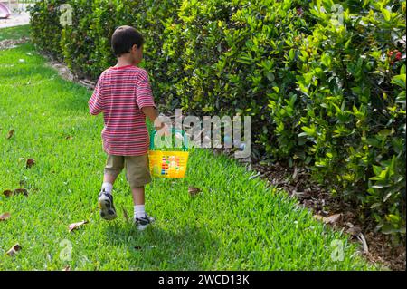 Junge, der in einem Park ostereier sucht Stockfoto