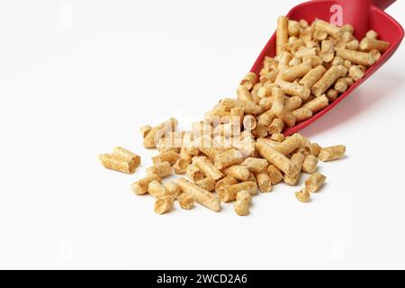 Rote Schaufel mit Holzpellets isoliert auf weiß Stockfoto