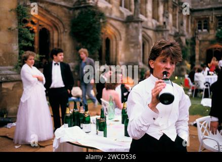 Student UK 1980s Oxford University Commem Bälle, allgemein bekannt als May Ball, finden im Juni statt. Der Student des Magdalen College ist betrunken, müde und trinkt Champagner aus einer Flasche. Am Morgen nach der Nacht davor war er die ganze Nacht auf und feierte. 1980er Jahre Oxford, England Juni 1985. HOMER SYKES Stockfoto