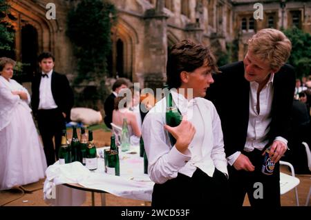 Oxford University Commem Bälle, allgemein bekannt als May Ball, finden im Juni statt. Der Student des Magdalen College ist betrunken, müde und trinkt Champagner aus einer Flasche. Am Morgen nach der Nacht davor war er die ganze Nacht auf und feierte. 1980er Jahre Oxford, England Juni 1985. UK HOMER SYKES Stockfoto