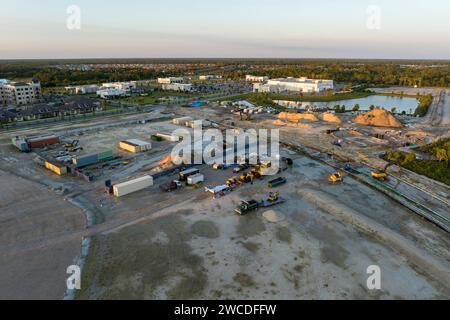 Entwicklung von Wohnhäusern in US-Vororten. Beginn der Bauarbeiten auf vorbereitetem Boden. Große Baustelle mit verstreuten Anlagen Stockfoto