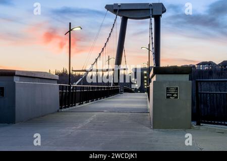 Edmonton, Kanada, 24. November 2023: Fort Edmonton Fußgängerbrücke bei Sonnenuntergang mit eingeschaltetem Nachtlicht Stockfoto