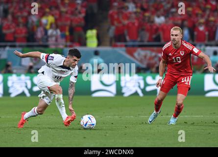 Christian Pulisic unternimmt den Boden, als er während des Gruppenspiels der USA in der WM 2022 versucht, einen Pass gegen Aaron Ramsey aus Wales zu kontrollieren. Stockfoto