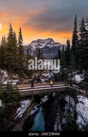 Eine schöne Landschaftsfotografie von Athabasca Falls im Jasper National Park im Winter bei einem feurigen und dynamischen Sonnenuntergang. Stockfoto