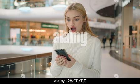 Schockiert überrascht Weiße Frau Klientin Kunde gen z Benutzer lesen Social-Media-Gadget süchtig glückliches Mädchen gewinnen erstaunliche Überraschung auf Handy Stockfoto