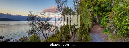 Sonnenuntergang, Frasers Beach und ein Wanderweg neben Lake Manapouri, Aotearoa (Neuseeland), Te Waipounamu (Südinsel). Der See befindet sich innerhalb des Stockfoto