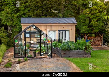 Kleines Haus mit Gewächshaus und Gemüsegarten in Manapouri, Aotearoa (Neuseeland), Te Waipounamu (Südinsel). Stockfoto