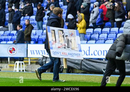 Reading, UK, 13. Januar 2024. Ein Reading-Unterstützer hält ein Plakat gegen die Vereinsbesitzer, während Reading-Fans während ihres Fußballspiels in der EFL-Liga One zu Hause gegen Port Vale auf dem Spielfeld einmarschieren. Das Spiel wird später aufgegeben. Quelle: TeeGeePix/Alamy Live News Stockfoto