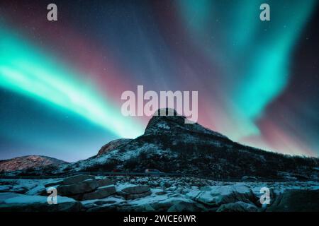 Nordlichter und schneebedeckte Berge bei Nacht. Aurora borealis Stockfoto