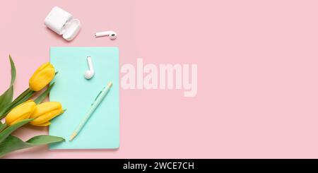 Moderne Ohrhörer, Notebook, Stift und schöne Tulpenblüten auf rosa Hintergrund mit Platz für Text Stockfoto