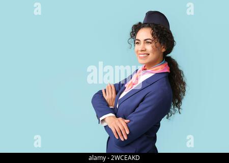 Wunderschöne afroamerikanische Stewardess auf blauem Hintergrund Stockfoto