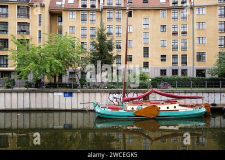 Das Boot ankerte an einem der Seitenkanäle der Spree mit Wohnhäusern am Ufer in Berlin Stockfoto
