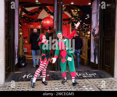 Zwei Elfen in festlichen Kostümen begrüßen die Kunden vor Weihnachten im Hamleys Store in London Stockfoto