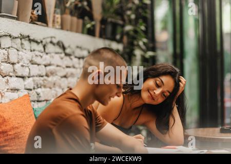 Schüler treffen sich in einem Café, lernen, diskutieren und surfen gemeinsam im Internet. Stockfoto