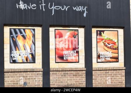 Halten Sie sich ein Schild an der Außenseite eines Burger King Fast-Food-Restaurants vor Stockfoto